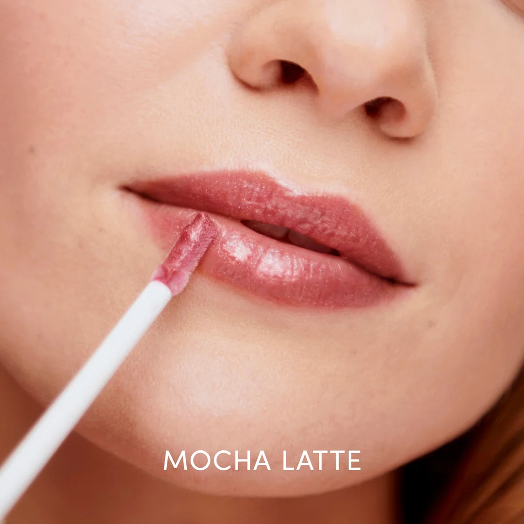 Close-up of a model applying jane iredale HydroPure Hyaluronic Lip Gloss in Mocha Latte with a wand applicator.