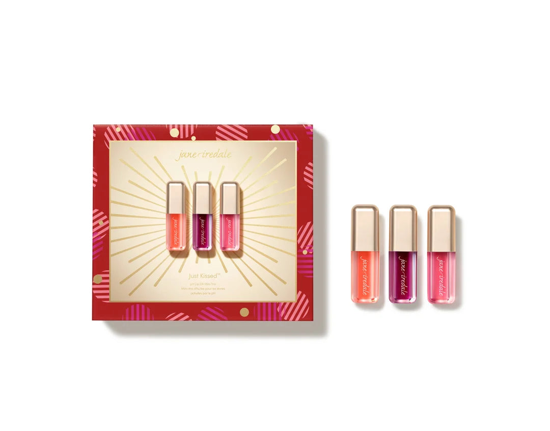 jane iredale Just Kissed holiday lip set in red and gold gift packaging beside three miniature lip products with gold-toned caps.