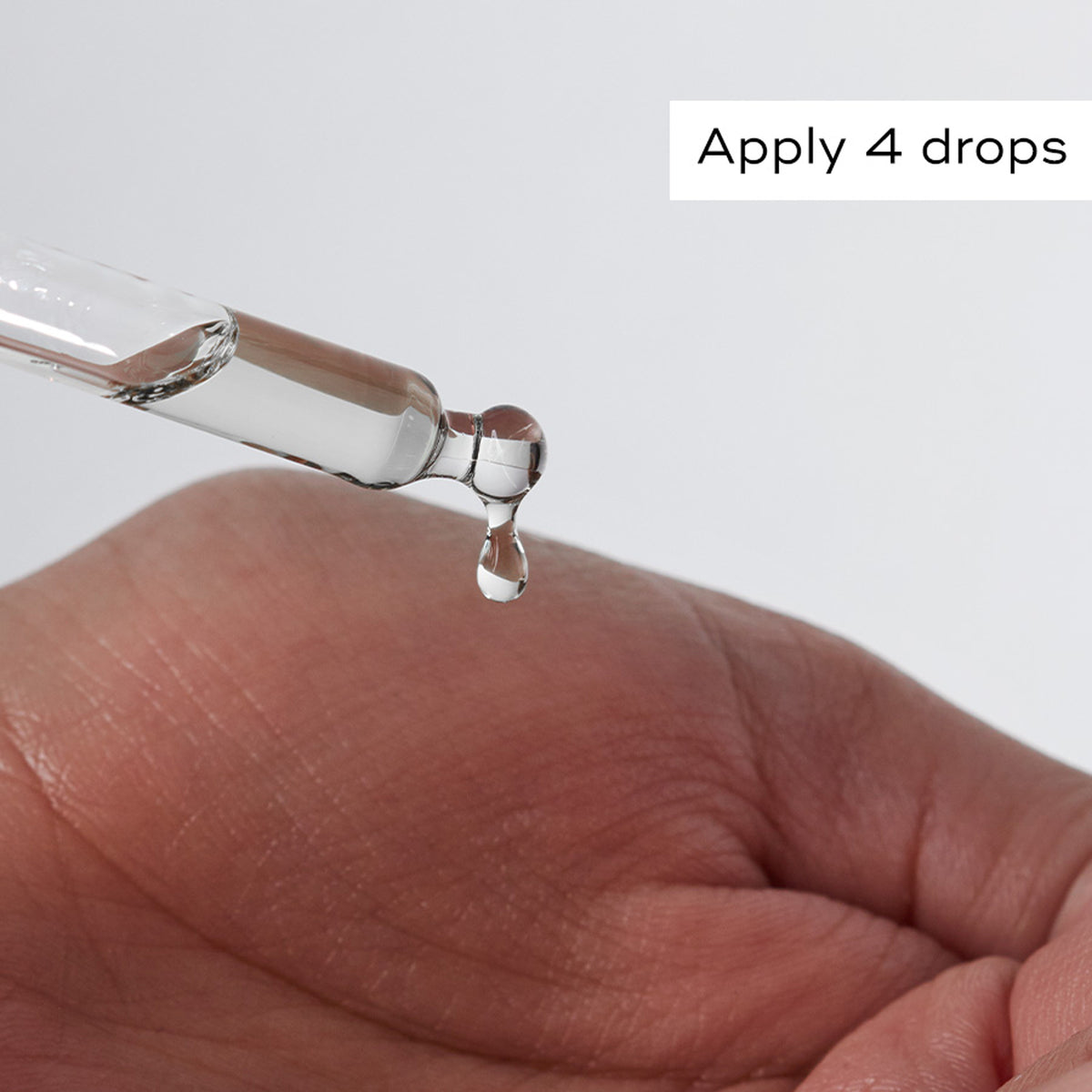 Glass dropper dispensing Medik8 Calmwise Serum onto a hand beside the instruction Apply 4 drops.