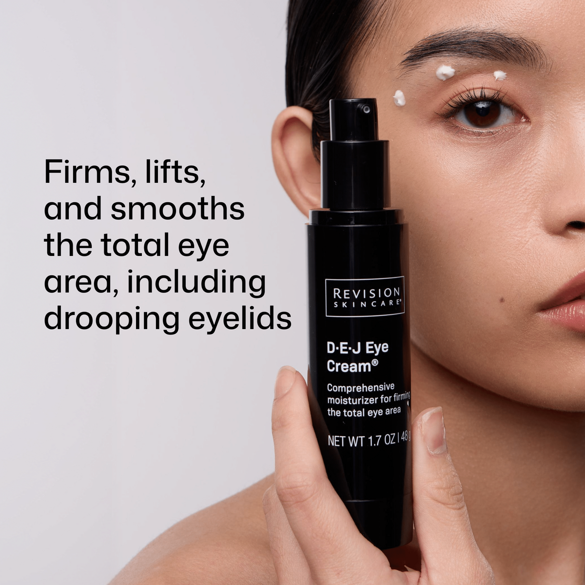 Model holding Revision Skincare D.E.J Eye Cream with dots of cream around the eye beside product benefit text.