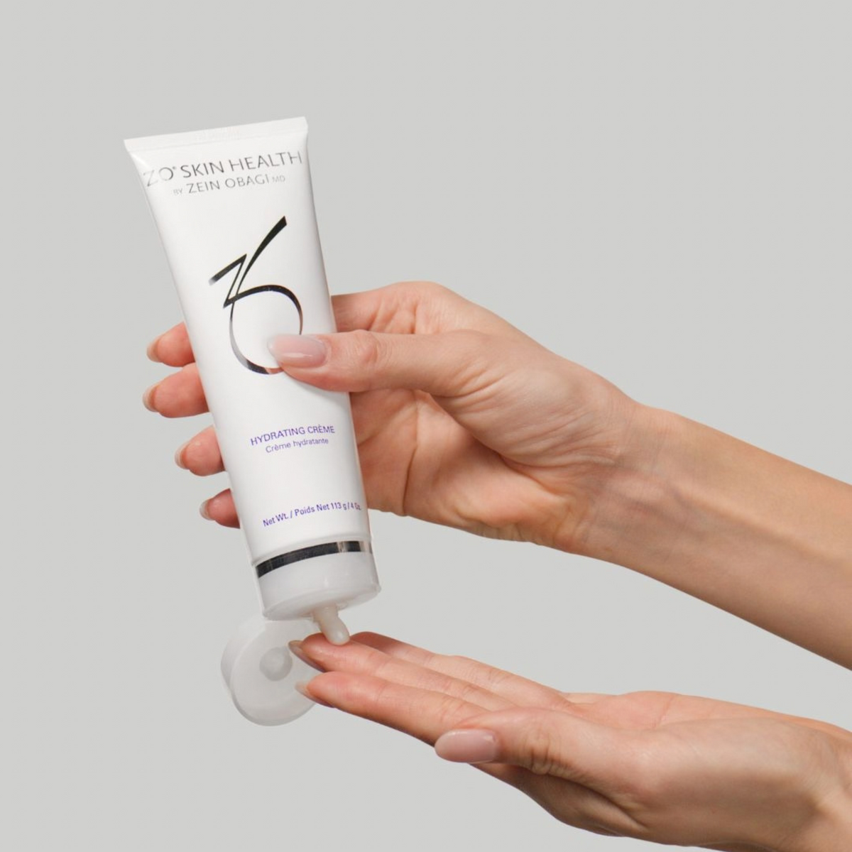 ZO Skin Health Hydrating Crème tube being dispensed into a hand